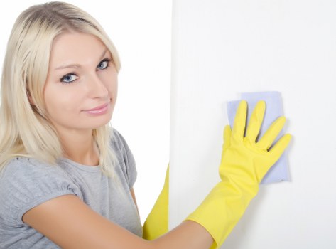 Cleaner making a bed and refreshing linen in a Queenspark Airbnb